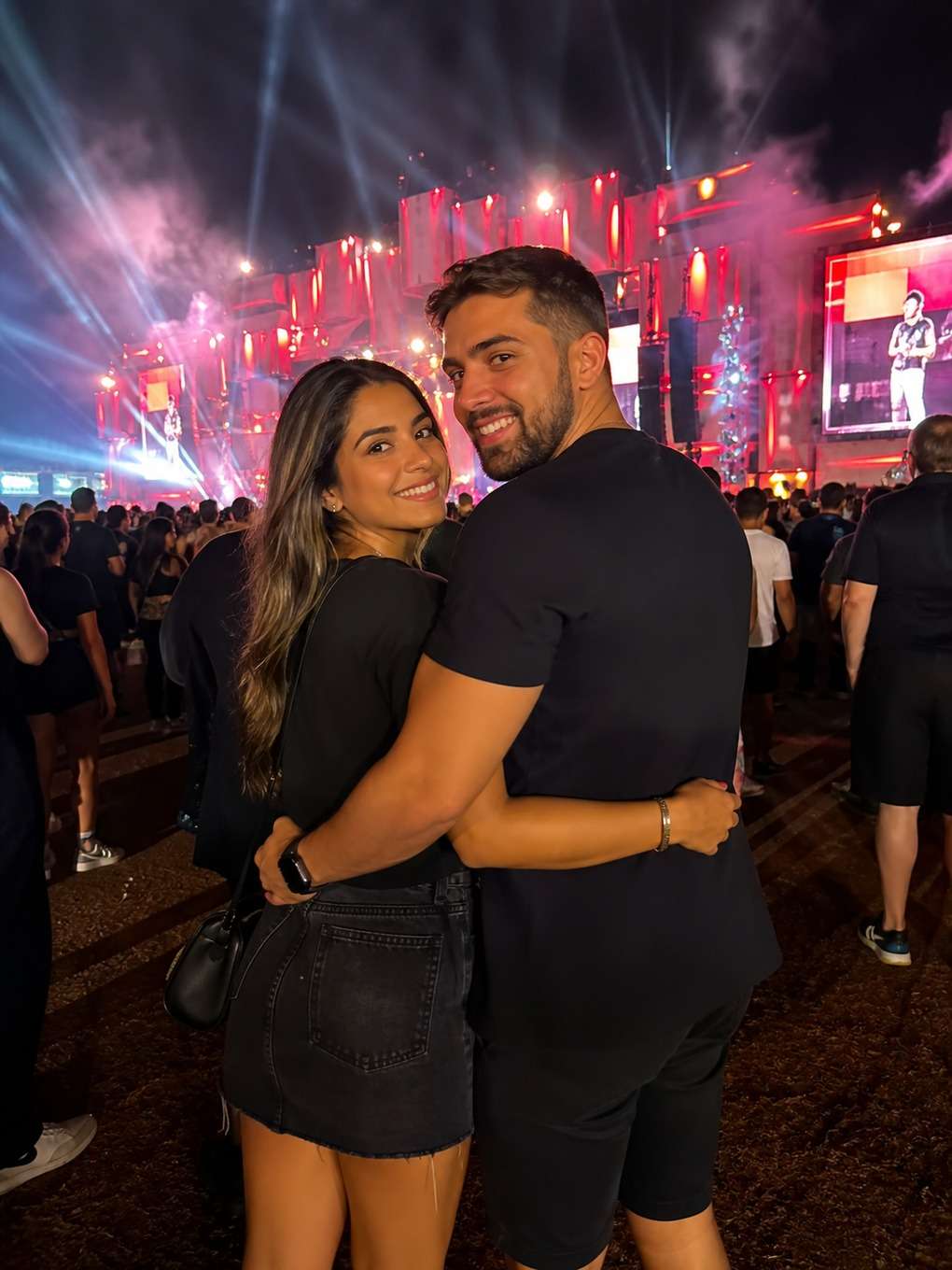 abraço com palco iluminado ao fundo - exemplo de fotos de casal no rock in rio